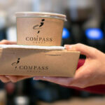 Compass Group take away food containers, held by employee